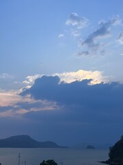 Blue sky at sunset. The sky is reflected in the sea. Sky with sun rays. Rainy sky.