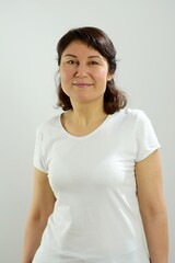 Obraz premium brunette in white T-shirt middle-aged woman with a smile on her face joy enthusiasm Delighted mother expecting children teacher social worker washing detergent facial skin care products for women