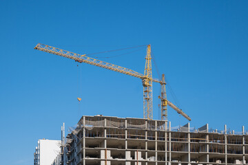 Construction cranes on the background of the sky. Building the skyscraper.