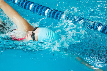 The theme of sports and endurance. Side view of a professional female swimmer with goggles at the...