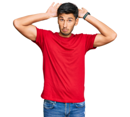 Young handsome man wearing casual red tshirt doing bunny ears gesture with hands palms looking cynical and skeptical. easter rabbit concept.