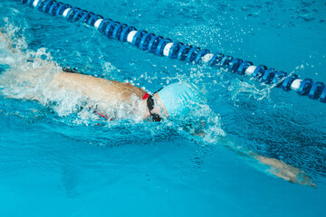Beautiful female swimmer using front bypass, freestyle in the pool. Preparing professional athletes...