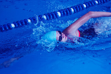 Beautiful female swimmer using front bypass, freestyle in the pool. Preparing professional athletes...