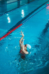 Synchronized girl working out tricks in the pool. Synchronized swimming, sports in the water....