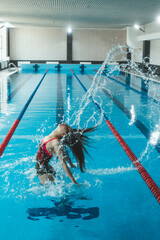 Synchronized girl working out tricks in the pool. Synchronized swimming, sports in the water....