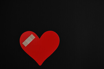 Corazón lastimado sobre fondo negro, espacio para texto al lado derecho.