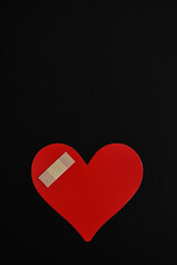 Corazón lastimado sobre fondo negro, espacio para texto en la parte superior.