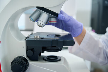 Laboratory employee works with a powerful microscope at the workplace