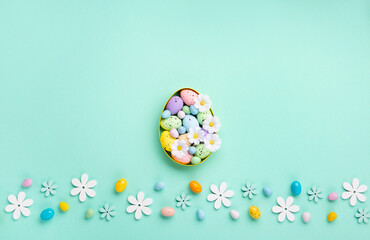 Fototapeta na wymiar Easter Eggs with Sweets and Spring Flowers on Blue Background
