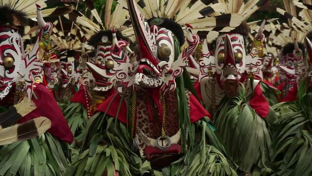 the scene of hudoq dancers marching in order to perform sacred rituals performed by indigenous tribes  