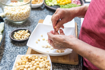 Hands of an adult woman peeling for fanesca