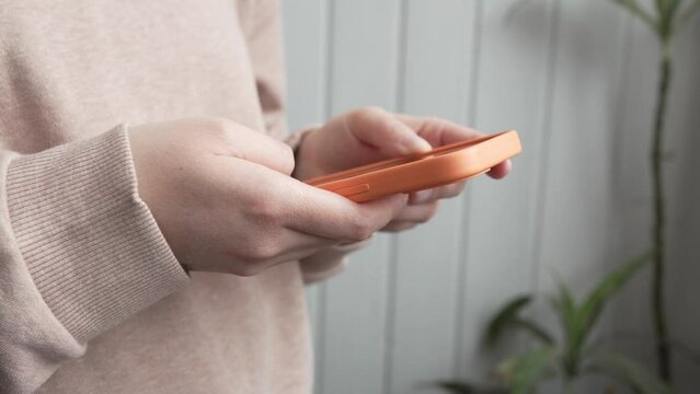 Midsection of unknown caucasian woman using smartphone mobile phone for texting send text messages or browsing internet social network