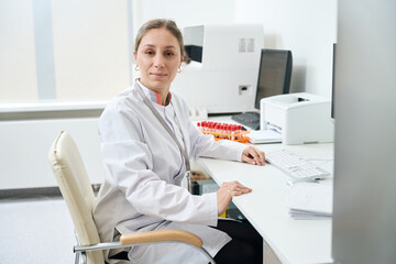 Laboratory employee is sitting at her desk