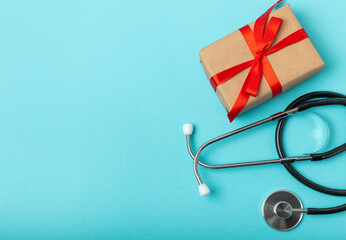 National Day of Doctors. Modern stethoscope, gift box and gingerbread in the form of medical supplies on a blue background. .Gingerbread in the form of a thermometer, a medical mask, a pill, a patch.