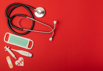 Modern stethoscope and gingerbread in the form of medical items on a red background. National Day of Doctors.