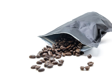 Black vacuum bag for coffee from which coffee beans spill out. Isolated on white.