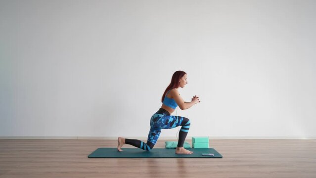 Athletic Woman Trainer Leads an Online Stretching Workout on a White Background. Online Learning Concept and E-learning. 