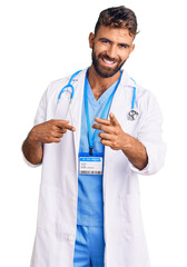 Young hispanic man wearing doctor uniform and stethoscope pointing fingers to camera with happy and funny face. good energy and vibes.