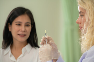 Woman Doctor Gently use hand syringe careful inject iller Botox liquid through skin patient for cosmetic beauty at cosmetic surgery department in hospital clinic.