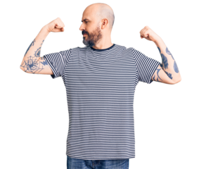 Young handsome man wearing casual clothes showing arms muscles smiling proud. fitness concept.