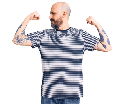 Young handsome man wearing casual clothes showing arms muscles smiling proud. fitness concept.