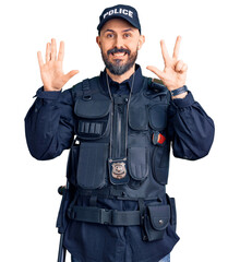 Young handsome man wearing police uniform showing and pointing up with fingers number eight while smiling confident and happy.