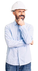 Young handsome man wearing architect hardhat looking confident at the camera smiling with crossed arms and hand raised on chin. thinking positive.