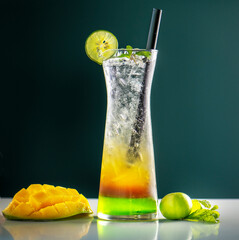 colorful cool ice tea lemonade cocktails in glasses with straw on gray background. Mix glass of...