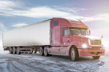 Red long-distance bonnet truck with a white semitrailer on bright background with sky