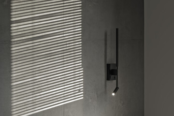 Minimalistic black wall light in modern interior in grey and black colours, concrete wall design, clay wall. Contemporary interior design aesthetics with concrete details