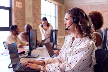 Multi-Cultural Business Team Wearing Headsets Working In Customer Support Centre