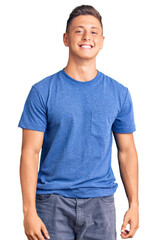 Young handsome hispanic man wearing casual clothes looking positive and happy standing and smiling...
