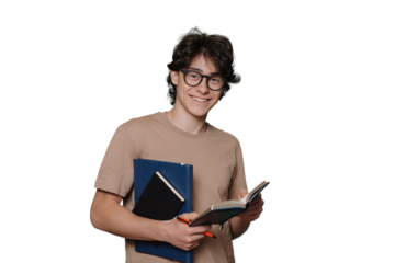 Smart Caucasian guy in glasses and beige t-shirt holds books, notebook, pen looks at camera standing against ttransparent background. Toothy smiling teen boy loves math, physics, chemistry. Education