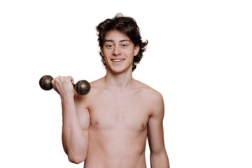 Fit young guy toothy smiles looks at camera holds dumbbell   stands against transparent background. Cheerful caucasian boy in perfect shape. Mockup, gym, fitness, workout. Strong teenager posing.
