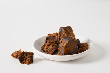Kithul jaggery and treacle natural sweetener in bowl on white background. Copy space. Close up. Alternative sugar. low GI food. Superfood .