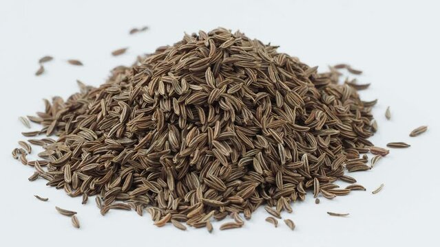 Pile of cumin seeds isolated on white background