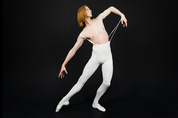Fototapeta na wymiar Young athletic professional ballet dancer with a bare torso and white dance tights is in perfect shape, performing and posing over a black background.