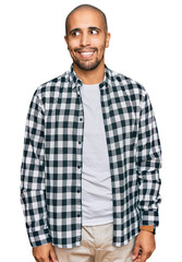 Hispanic adult man wearing casual clothes smiling looking to the side and staring away thinking.