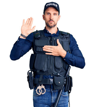 Young handsome man wearing police uniform swearing with hand on chest and open palm, making a loyalty promise oath