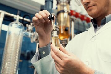 A scientist or apothecary extracts CBD hemp oil for medicinal purposes in a laboratory. Alternative cannabis-based medicine produced from cannabis extraction machine.