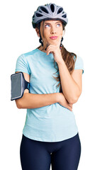 Beautiful caucasian young woman wearing bike helmet serious face thinking about question with hand on chin, thoughtful about confusing idea