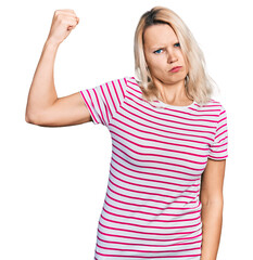 Young caucasian woman wearing casual clothes strong person showing arm muscle, confident and proud of power