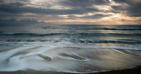 Fototapeta na wymiar Seascape with sea waves crashing in the coast at sunset