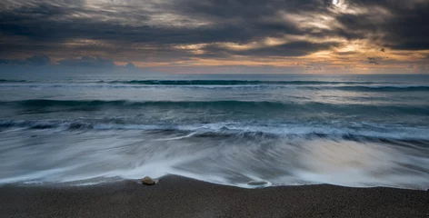 Foto auf Leinwand Seascape with sea waves crashing in the coast at sunset © Michalis Palis
