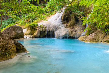 Fototapeta na wymiar Waterfall in tropical landscape, green trees in wild jungle forest. Erawan National park, Kanchanaburi, Thailand