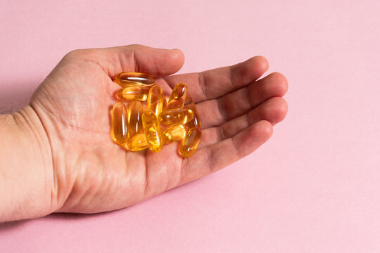 Mano sosteniendo capsulas de Omega 3 - Hand holding Omega 3 capsules
