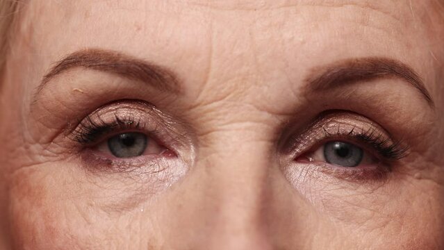 Close-up image of female beautiful eyes. Middle-aged, mature woman with well-kept healthy skin with wrinkles. Concept of natural beauty, face skin care, cosmetology and cosmetics, health