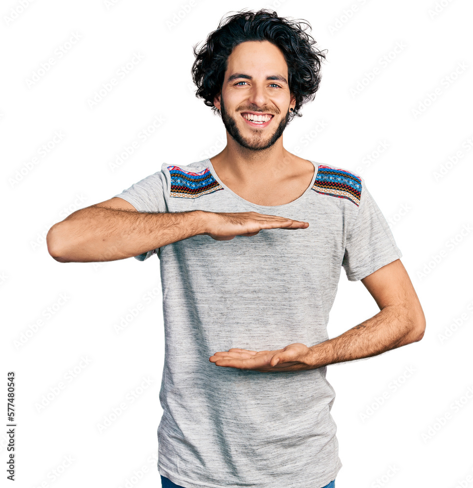 Sticker young hispanic man wearing casual t shirt gesturing with hands showing big and large size sign, meas