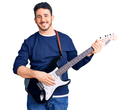 Young hispanic man playing electric guitar looking positive and happy standing and smiling with a confident smile showing teeth