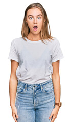 Beautiful young blonde woman wearing casual white t shirt afraid and shocked with surprise and amazed expression, fear and excited face.